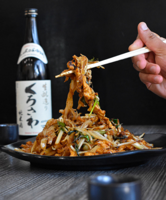 photo of a person holding chopsticks picking up noodles from Zen Modern Asian Bistro - Photo taken by Black X Marketing